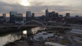 5.7K aerial stock footage of a view of the Cumberland River, bridges, and city skyline at sunset, Downtown Nashville, Tennessee Aerial Stock Footage | DX0002_119_032