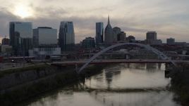 5.7K aerial stock footage follow the river to approach the bridge and city skyline at sunset, Downtown Nashville, Tennessee Aerial Stock Footage | DX0002_119_035