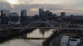 5.7K aerial stock footage of the city skyline by bridges and Cumberland River at sunset, Downtown Nashville, Tennessee Aerial Stock Footage | DX0002_119_042