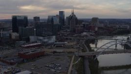 5.7K aerial stock footage approach city skyline near a bridge on Cumberland River at sunset, and descend, Downtown Nashville, Tennessee Aerial Stock Footage | DX0002_119_049