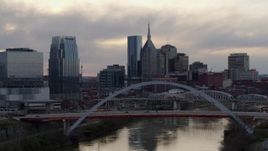 5.7K aerial stock footage city skyline seen while passing bridge on Cumberland River at sunset, Downtown Nashville, Tennessee Aerial Stock Footage | DX0002_120_001