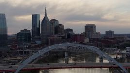 5.7K aerial stock footage approach riverfront skyline, ascend over bridge and Cumberland River at sunset, Downtown Nashville, Tennessee Aerial Stock Footage | DX0002_120_005