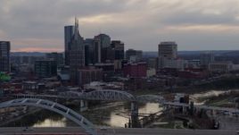 5.7K aerial stock footage flying by and away from riverfront skyline, bridges, and Cumberland River at sunset, Downtown Nashville, Tennessee Aerial Stock Footage | DX0002_120_006