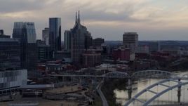 5.7K aerial stock footage of the AT&T Building and neighboring buildings by the Cumberland River at sunset, Downtown Nashville, Tennessee Aerial Stock Footage | DX0002_120_010