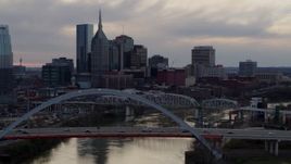 5.7K aerial stock footage flying by the riverfront skyscrapers and bridges spanning the Cumberland River at sunset, Downtown Nashville, Tennessee Aerial Stock Footage | DX0002_120_011