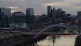5.7K aerial stock footage reverse view of Pinnacle skyscraper and a bridge on the river at sunset, Downtown Nashville, Tennessee Aerial Stock Footage | DX0002_120_018