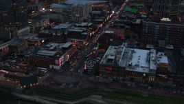 5.7K aerial stock footage orbiting buildings, cars and pedestrians around Broadway at twilight, Downtown Nashville, Tennessee Aerial Stock Footage | DX0002_120_025