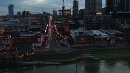5.7K aerial stock footage of circling buildings, cars and pedestrians around Broadway at twilight, Downtown Nashville, Tennessee Aerial Stock Footage | DX0002_120_027