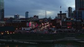 5.7K aerial stock footage descend and flyby riverfront buildings, cars on Broadway at twilight, Downtown Nashville, Tennessee Aerial Stock Footage | DX0002_120_029