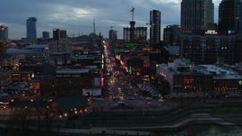 5.7K aerial stock footage of riverfront buildings, cars on Broadway at twilight during ascent, Downtown Nashville, Tennessee Aerial Stock Footage | DX0002_120_030