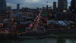 5.7K aerial stock footage reverse view of riverfront buildings, cars on Broadway at twilight, Downtown Nashville, Tennessee Aerial Stock Footage | DX0002_120_031