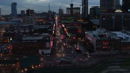 5.7K aerial stock footage flying toward traffic and pedestrians on Broadway at twilight, Downtown Nashville, Tennessee Aerial Stock Footage | DX0002_120_032