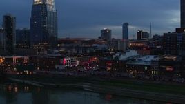 5.7K aerial stock footage fly away from traffic and riverfront buildings at the end of Broadway at twilight, Downtown Nashville, Tennessee Aerial Stock Footage | DX0002_120_034