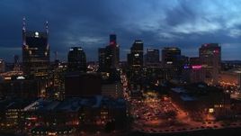 5.7K aerial stock footage of flying away from the city's skyline at twilight, seen from Cumberland River, Downtown Nashville, Tennessee Aerial Stock Footage | DX0002_121_003