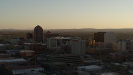5.7K aerial stock footage of a reverse view of high-rise office buildings at sunset, Downtown Albuquerque, New Mexico Aerial Stock Footage | DX0002_122_032