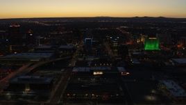 5.7K aerial stock footage ascend and orbit DoubleTree hotel with blue lighting near office buildings at twilight, Downtown Albuquerque, New Mexico Aerial Stock Footage | DX0002_123_032
