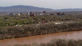5.7K aerial stock footage of high-rise office buildings seen while ascending by the Rio Grande, Downtown Albuquerque, New Mexico Aerial Stock Footage | DX0002_124_002