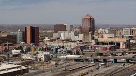 5.7K aerial stock footage of an office high-rise seen while ascending near train tracks, Downtown Albuquerque, New Mexico Aerial Stock Footage | DX0002_124_021