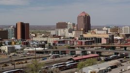 5.7K aerial stock footage office high-rise towering over city buildings, seen from railroad tracks, Downtown Albuquerque, New Mexico Aerial Stock Footage | DX0002_124_023