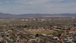 5.7K aerial stock footage flying by suburban homes with a view of Downtown Albuquerque in the distance, New Mexico Aerial Stock Footage | DX0002_126_001