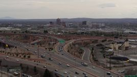 5.7K aerial stock footage of Downtown Albuquerque buildings seen while descending past freeway interchange traffic, New Mexico Aerial Stock Footage | DX0002_126_028