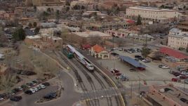 5.7K aerial stock footage fly away from passenger train at the station in Santa Fe, New Mexico, tilt to top of the train Aerial Stock Footage | DX0002_130_019