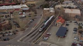5.7K aerial stock footage fly away from bird's eye of a passenger train at a station in Santa Fe, New Mexico, tilt to top of the train Aerial Stock Footage | DX0002_130_021