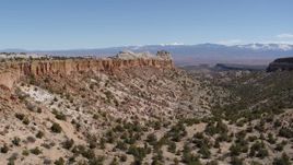 5.7K aerial stock footage of slowly approaching a desert mesas, mountains in distance, in New Mexico Aerial Stock Footage | DX0002_133_010