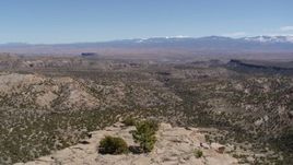 5.7K aerial stock footage fly over the top of a desert mesa for wide view of mesas and mountains in New Mexico Aerial Stock Footage | DX0002_133_012