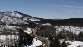 5.7K aerial stock footage of following a winding road by snowy mountains, New Mexico Aerial Stock Footage | DX0002_134_029