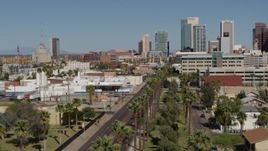 5.7K aerial stock footage fly over palm trees at city park toward tall office buildings in Downtown Phoenix, Arizona Aerial Stock Footage | DX0002_137_036