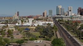 5.7K aerial stock footage flying by city parks and a street leading to tall office buildings in Downtown Phoenix, Arizona Aerial Stock Footage | DX0002_137_039