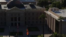 5.7K aerial stock footage fly away from flags in front of the Arizona State Capitol building in Phoenix, Arizona Aerial Stock Footage | DX0002_137_068