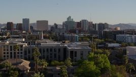 5.7K aerial stock footage of a view over rooftops at high-rise office buildings in the distance in Downtown Phoenix, Arizona Aerial Stock Footage | DX0002_138_033