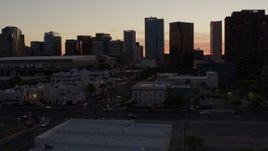 5.7K aerial stock footage of passing tall office buildings at sunset, reveal college buildings in Downtown Phoenix, Arizona Aerial Stock Footage | DX0002_139_005