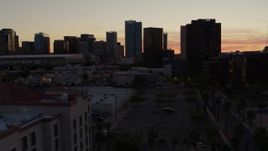 5.7K aerial stock footage of passing college buildings to focus on office high-rises at sunset in Downtown Phoenix, Arizona Aerial Stock Footage | DX0002_139_006