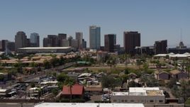 5.7K aerial stock footage of flying by the city's skyline, and then away from it, seen from homes in Downtown Phoenix, Arizona Aerial Stock Footage | DX0002_140_013