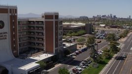 5.7K aerial stock footage approach hospital complex, pan to street and reveal skyline in Phoenix, Arizona Aerial Stock Footage | DX0002_140_021