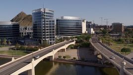 5.7K aerial stock footage fly away from waterfront office buildings, seen from between two bridges in Tempe, Arizona Aerial Stock Footage | DX0002_142_013