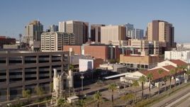 5.7K aerial stock footage of the city's skyline seen between a parking garage and train station in Downtown Phoenix, Arizona Aerial Stock Footage | DX0002_142_019