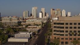 5.7K aerial stock footage the city's skyline at sunset while flying by street to reveal state office building in Downtown Phoenix, Arizona Aerial Stock Footage | DX0002_143_007