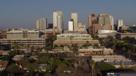 5.7K aerial stock footage reverse view of city's skyline at sunset, cross street to reveal state building in Downtown Phoenix, Arizona Aerial Stock Footage | DX0002_143_010
