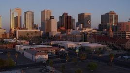 5.7K aerial stock footage of passing by tall office towers in the city's skyline at sunset before descent, Downtown Phoenix, Arizona Aerial Stock Footage | DX0002_143_043