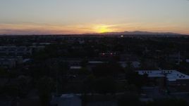 5.7K aerial stock footage of the sun setting behind distant mountains, seen from Phoenix, Arizona Aerial Stock Footage | DX0002_143_051
