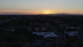 5.7K aerial stock footage of a view of the sun setting behind distant mountains, seen from Phoenix, Arizona Aerial Stock Footage | DX0002_143_052
