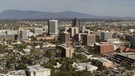 5.7K aerial stock footage reverse view of tall office high-rises surrounded by city buildings in Downtown Tucson, Arizona Aerial Stock Footage | DX0002_144_035