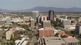 5.7K aerial stock footage ascend and fly away from tall office high-rises surrounded by city buildings in Downtown Tucson, Arizona Aerial Stock Footage | DX0002_144_038