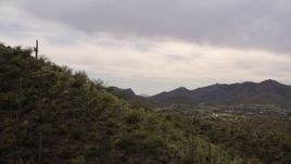 5.7K aerial stock footage fly over small peak with cactus plants, reveals homes and golf course in Tucson, Arizona Aerial Stock Footage | DX0002_145_002