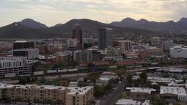 5.7K aerial stock footage orbit office towers as a train passes, with Sentinel Peak in the background, Downtown Tucson, Arizona Aerial Stock Footage | DX0002_145_036