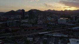 5.7K aerial stock footage passing tall office towers and city buildings with view of Sentinel Peak at sunset in Downtown Tucson, Arizona Aerial Stock Footage | DX0002_146_033